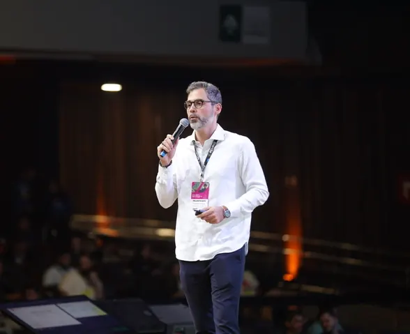 Osvaldo Aranha no palco do StartSe Fintech 2025, com a plateia à frente